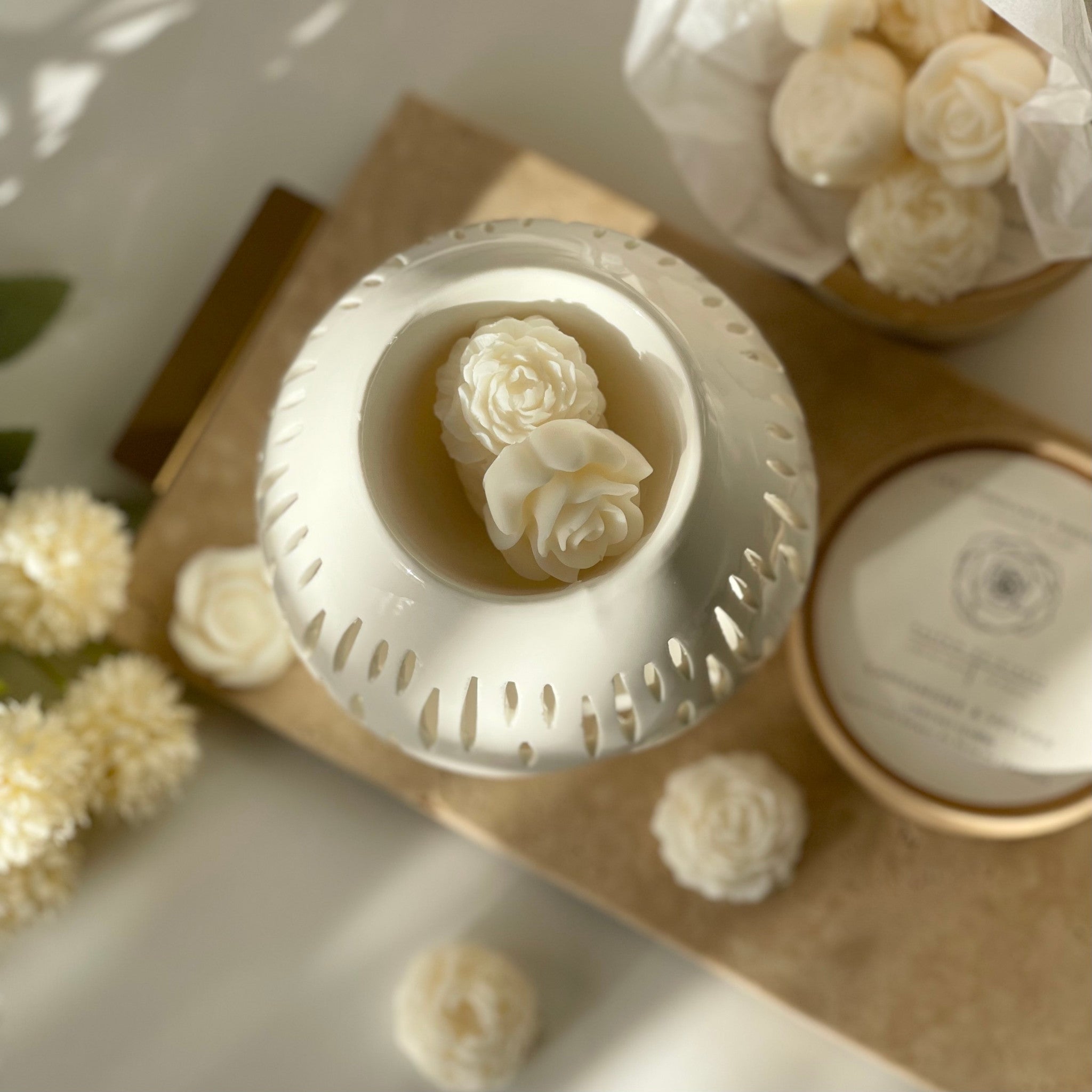 Les fondants parfumés en forme de fleurs délicates dans le brûle parfum blanc